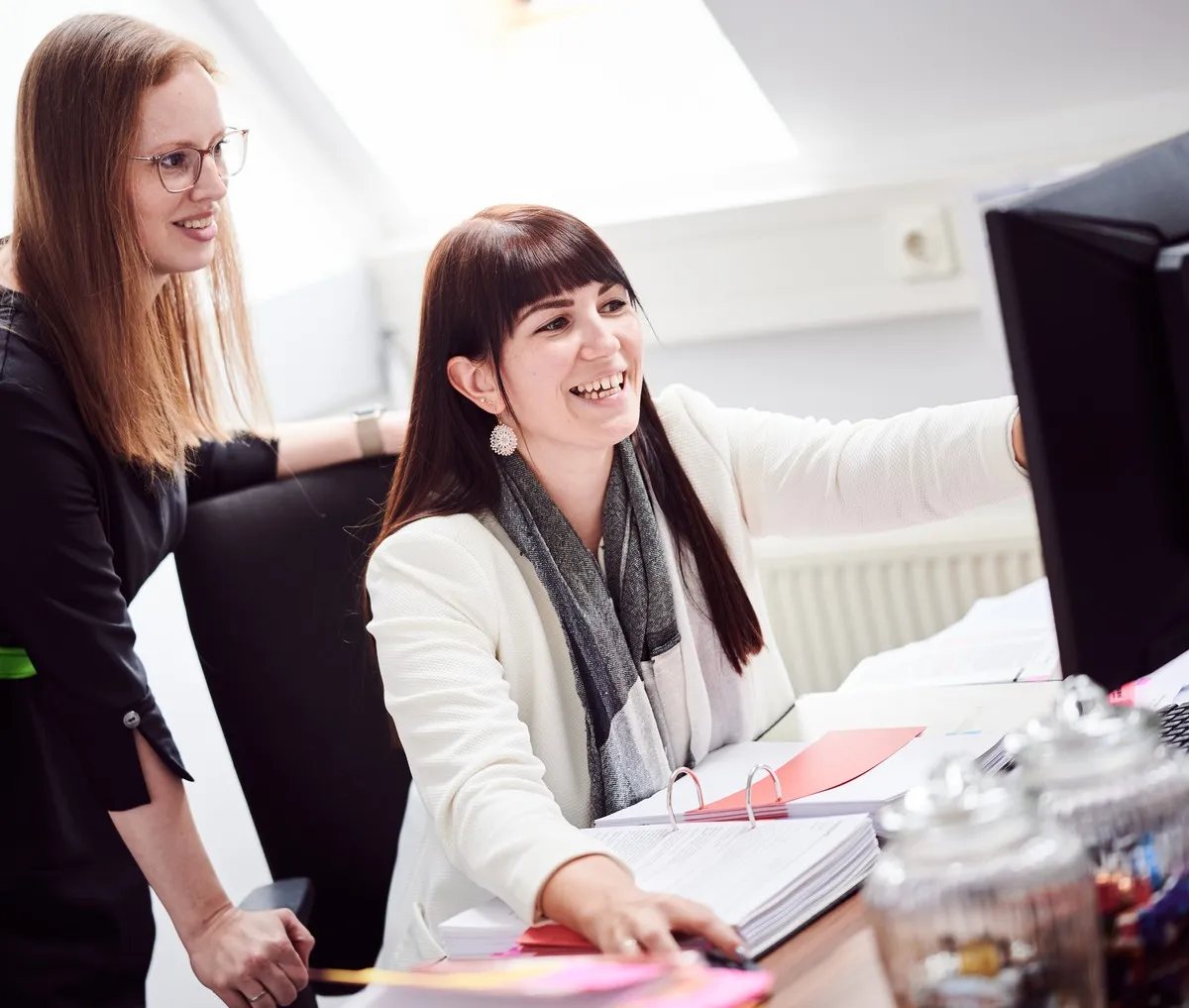 Zwei Mitarbeiterinnen besprechen sich am Bildschirm